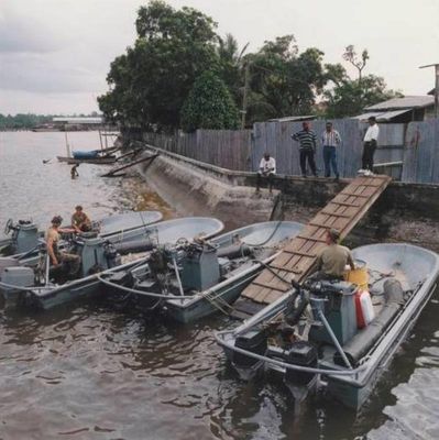 Vier Rigid Raiding Crafts liggen aan een kade ergens op Guyana tijdens een jungletraining, 1996.jpg